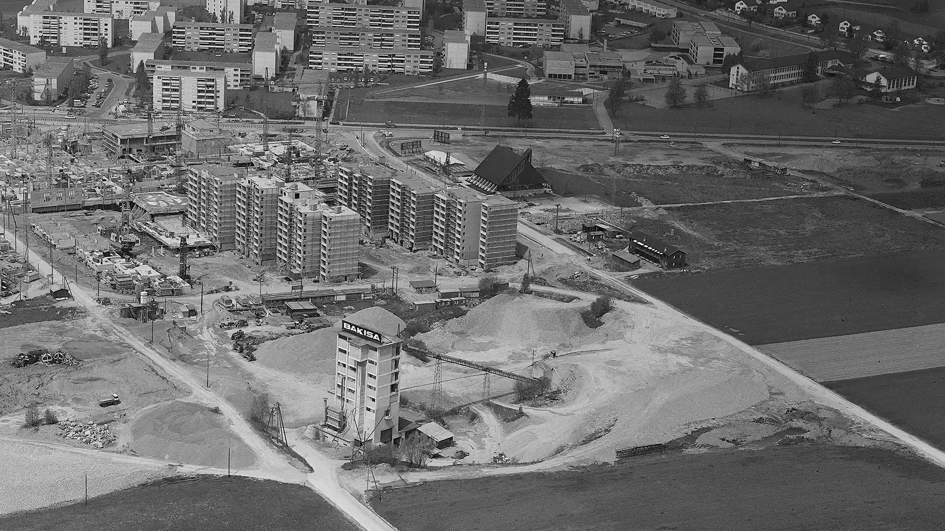 Aufnahme 1972: Gries, Volketswil. Vor der dreieckig erbauten Katholischen-Kirche entstand 2009 die bahoge-Siedlung. Am Ort der früheren Kiesgrube liegt nun als Erholungsgebiet der Park Im Gries.